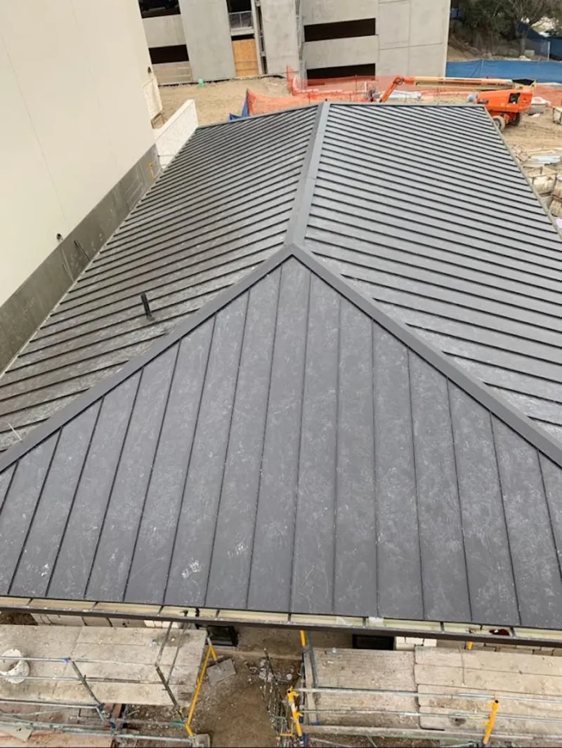 Commercial metal roof construction with crane equipment in New Haven